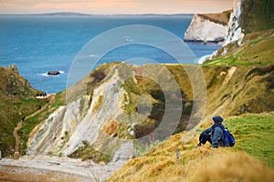 Tourist enjoying view of Man O`War Cove on the Dorset coast in southern England, between the headlands of Durdle Door to the west