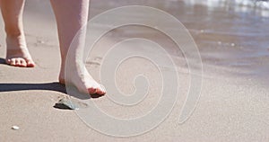 Tourist enjoys walking on sand beach washed by sea water