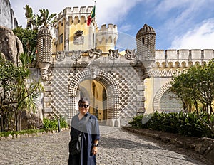 Tourist, entrance arch of The Pena Palace, a Romanticist Castle in Sao Pedro de Penaferim, in Sintra, on the Portuguese Riviera.