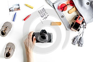 Tourist equipment with toys and camera for traveling with kids on white background top view