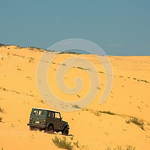 Tourist escapade Yellow sand dunes with a Jeep car