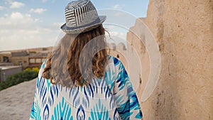 Tourist in ethnic dress at city walls Ichan Kala of Khiva