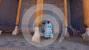 Tourist in ethnic dress at city walls Ichan Kala of Khiva