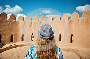 Tourist in ethnic dress at city walls Ichan Kala of Khiva