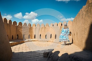 Tourist in ethnic dress at city walls Ichan Kala of Khiva