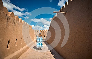 Tourist in ethnic dress at city walls Ichan Kala of Khiva