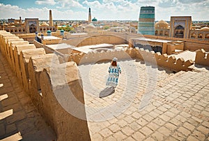 Tourist in ethnic dress at city walls Ichan Kala of Khiva