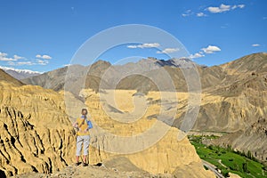 Tourist during expedition in the mountains Ladakh is admiring the beautiful Karakorum panorama in the vicinity of the Lamayuru tow