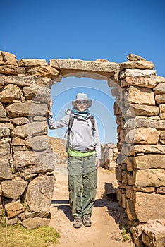 Tourist exploring the ancient mysterious Inca labyrinth-like settlement, called Chinkana, on the Island of the Sun, Titicaca Lake,