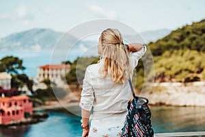 Tourist female in greek small vivid colored Assos village in morning. Kefalonia, Greece. Sommer vacation holiday vibes