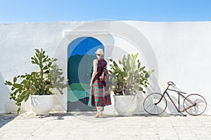 Tourist in front of Blue door with cactus and the traditional white walls in the town of Ostuni (Puglia - Italy