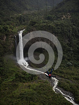 Tourist on giant swing adventure ride at Manto de la novia Bridal Veil waterfall Pastaza river Banos Tungurahua Ecuador photo