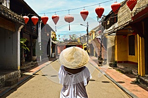 Woman with vietnamese hat in the historic street of Hoi An Vietnan photo