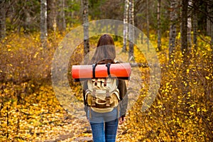 Tourist girl with backpack in the autumn forest