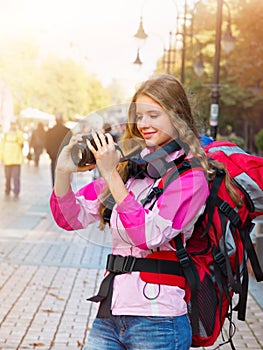 Tourist girl with backpack taking pictures on dslr camera