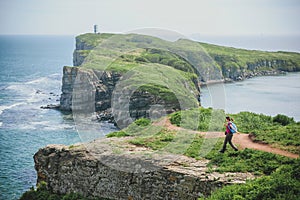 Tourist girl with a backpack in the wild of the Primorye Far East of Russia, Russky Island, Cape Tobizina