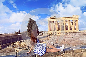 Tourist girl dressed in Greece flag colors looking at Parthenon