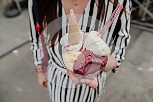 Tourist girl holding tasty traditional italian gelatto ice cream in her hands