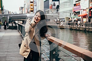 Tourist girl laughing relying on the handrail