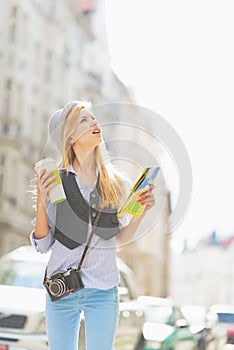 Tourist girl with map looking for something on city street