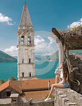 Tourist girl in Montenegro. Young traveller sightseeing bell tow