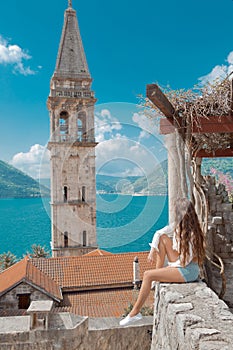 Tourist girl in Montenegro. Young traveller sightseeing bell tow
