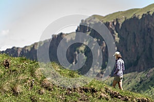 A tourist girl in a mountain landscape with a deep gorge. mountains, green pass. Picturesque landscapes with beautiful hills and