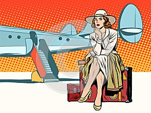 Tourist girl sitting on a suitcase, travelling by plane