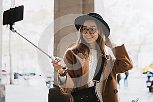 Tourist girl taking photo selfie on smartphone mobile. Girl hipster smiling travels in spain. Holiday concept street. Traveler