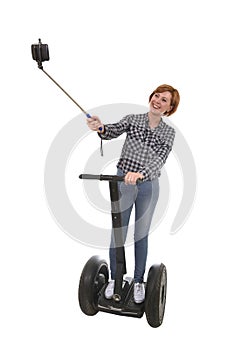 Tourist girl taking selfie photo with mobile phone while riding on segway