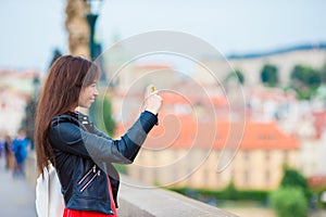 Tourist girl taking travel photos by famous attraction with smartphone on summer holidays. Young attractive tourist