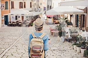 Tourist girl walking in the city during vacation. Cheerful woman traveling abroad in summer. Travel and active lifestyle concept