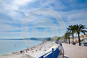 Tourist girl in white dress enjoying on promenade in Nice, France