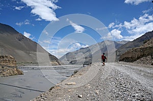 Tourist goes along the banks of the Kali Gandaki River, against the backdrop of the Himalayan mountains.
