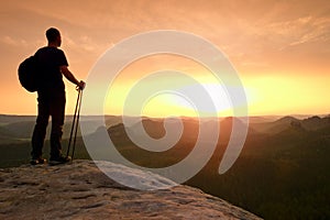 Tourist guide proped against pole in hand. Hiker with sporty backpack