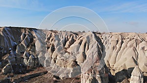 Tourist guy admires World Heritage, Cappadocia, Gereme, Turkey. Beautiful mountains of volcanic origin.