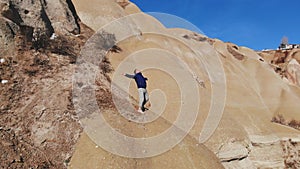 Tourist guy admires World Heritage, Cappadocia, Gereme, Turkey. Beautiful mountains of volcanic origin.