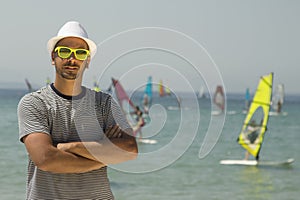 Tourist guy portrait and windsurfers in the background at the beach