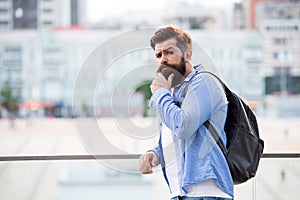 Tourist handsome hipster with backpack stand street. Man with beard and rucksack explore city. Travelling and adventures