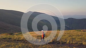 Tourist hiker with a backpack walking on mountain path in Carpathian mountains. Man tourist hiking on rocky desert terrain.