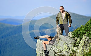 Tourist hiker girl and man relaxing. Hiking benefits. Hiking weekend. On edge of world. Woman sit edge of cliff high