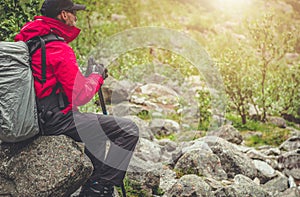 Tourist Hiker Relaxing Seating on a Boulder
