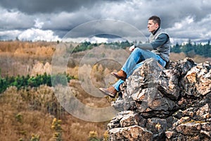 Tourist hiker sitting on the rock in mountain