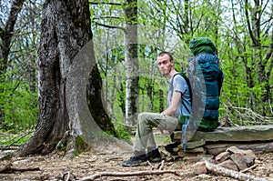 A tourist with a Hiking backpack sitting on a rock