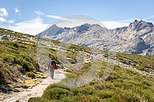 Tourist hiking on a trail to the Laguna Grande de Gredos, Sierra de Gredos mountains, Spain photo
