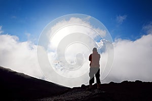 Tourist hiking in Haleakala volcano crater on the Sliding Sands trail. Beautiful view of the crater floor and clouds below. Maui,