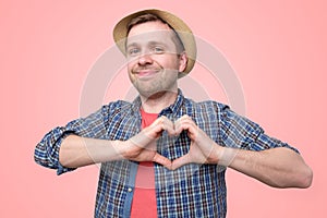 Tourist holding hands in heart gesture and smiling