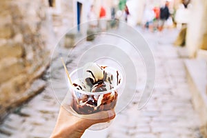 Tourist holds Fritule on street in Croatia. Croatian homemade fr