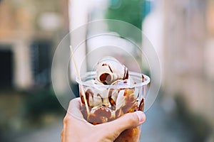 Tourist holds Fritule on street in Croatia. Croatian homemade fr