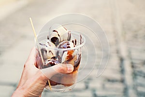 Tourist holds Fritule on street in Croatia. Croatian homemade fr